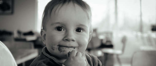 Neonato che mangia un biscotto